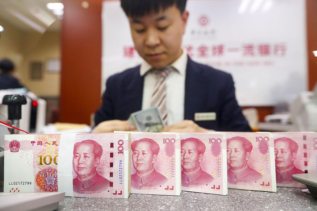 A bank employee counts money. Photo: VCG